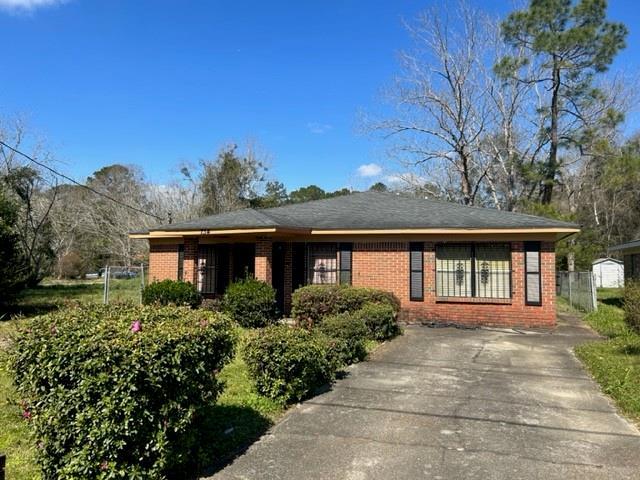 view of front of house featuring brick siding and fence