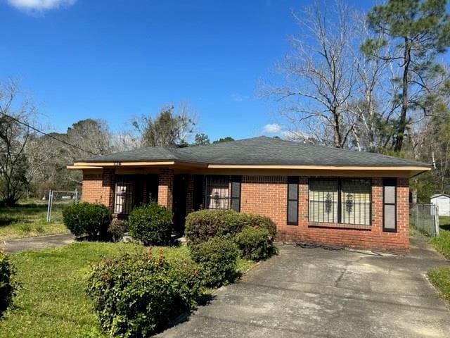 view of front of property featuring brick siding and concrete driveway