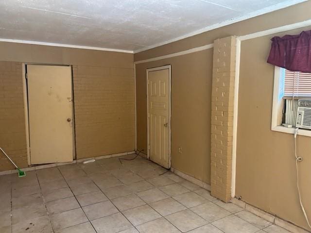 unfurnished room featuring light tile patterned floors and ornamental molding