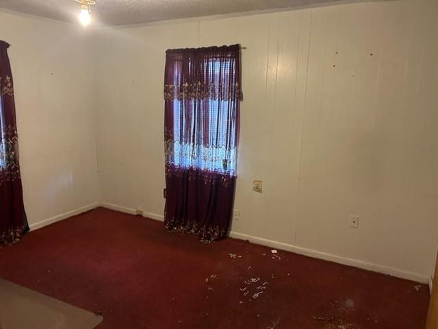 empty room with baseboards and a textured ceiling