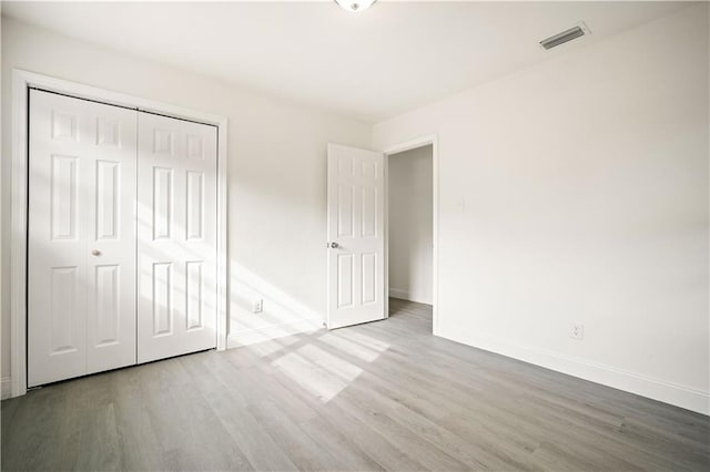 unfurnished bedroom featuring a closet and wood-type flooring