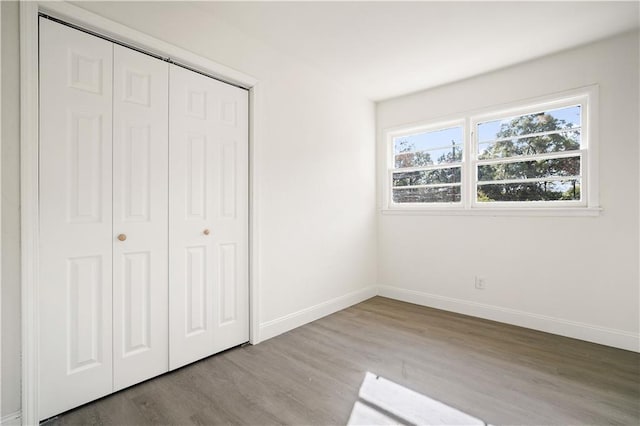 unfurnished bedroom featuring light hardwood / wood-style flooring and a closet