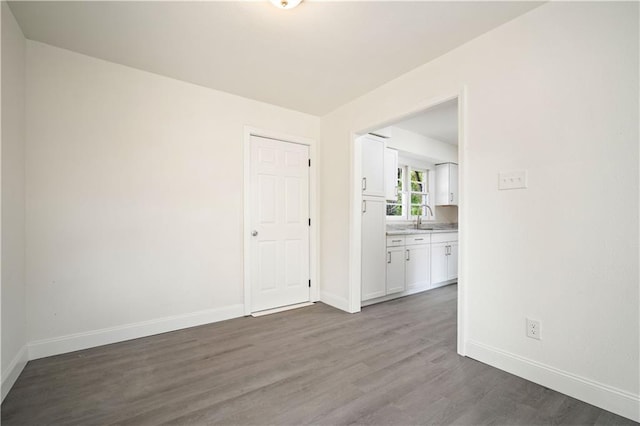 spare room featuring sink and dark wood-type flooring