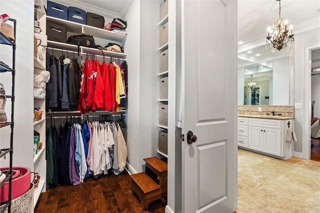 spacious closet featuring an inviting chandelier and sink