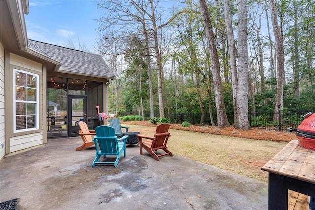 view of patio with a sunroom, ceiling fan, and an outdoor fire pit