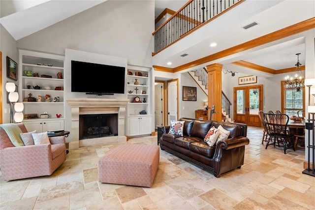 living room with built in shelves, an inviting chandelier, french doors, and a high ceiling