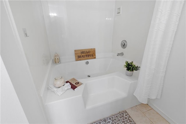 bathroom with tile patterned flooring and a bath