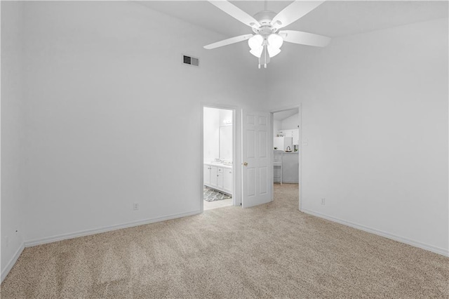 unfurnished bedroom featuring connected bathroom, light colored carpet, and ceiling fan