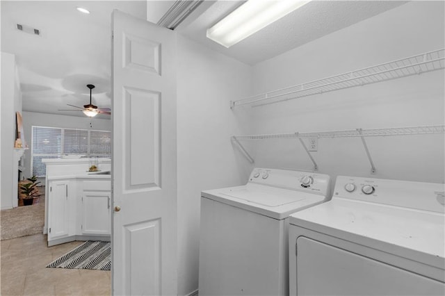 laundry room featuring separate washer and dryer, ceiling fan, and light tile patterned flooring