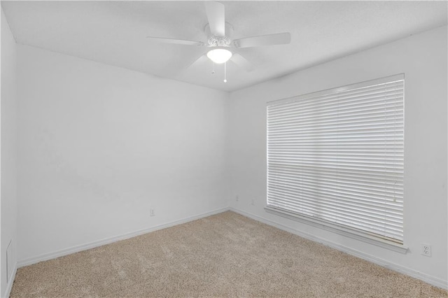 carpeted spare room with ceiling fan