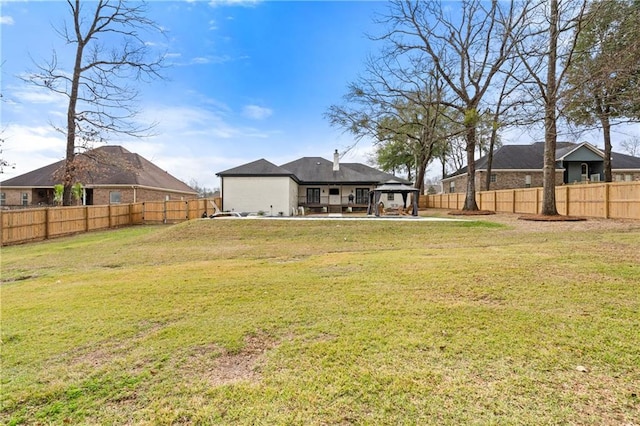 back of house featuring a gazebo and a yard