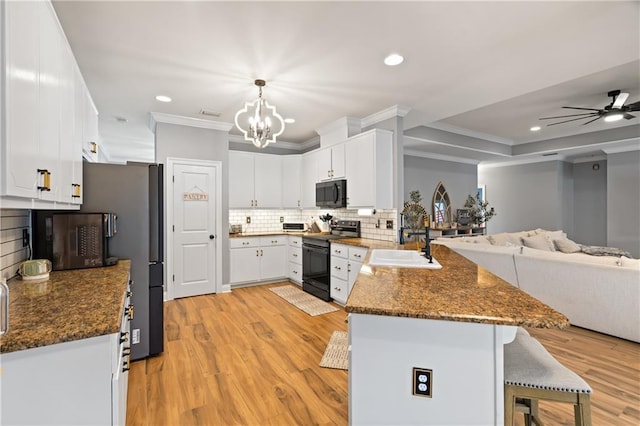 kitchen featuring pendant lighting, range with electric cooktop, kitchen peninsula, and white cabinets