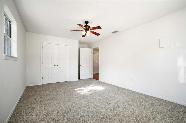 unfurnished bedroom featuring carpet, ceiling fan, and a closet