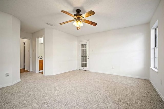 carpeted spare room featuring ceiling fan