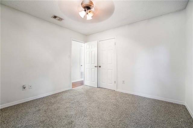 unfurnished bedroom with ceiling fan, carpet floors, and a closet