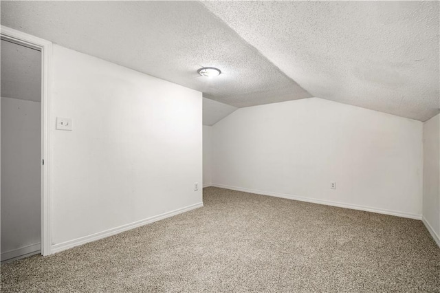 additional living space featuring a textured ceiling, carpet floors, and lofted ceiling