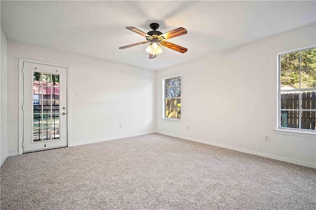 unfurnished room with ceiling fan, a healthy amount of sunlight, and carpet floors