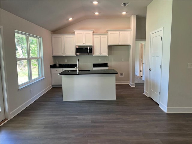 kitchen with sink, a center island with sink, dark hardwood / wood-style floors, white cabinetry, and lofted ceiling