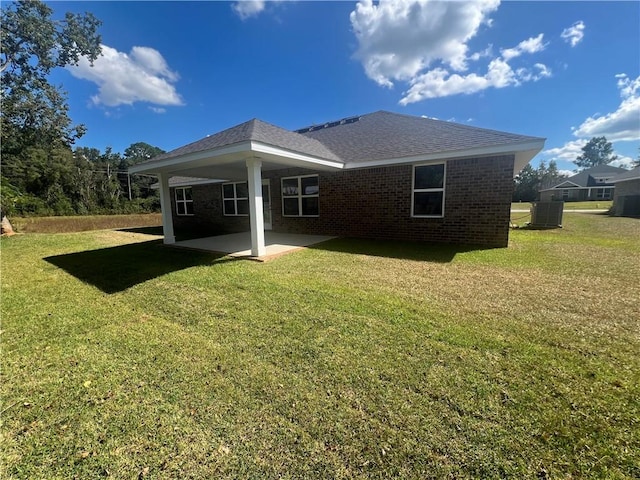 back of property with a yard, central AC unit, and a patio area