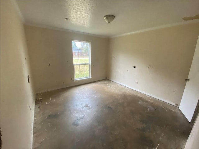 spare room featuring concrete floors and crown molding