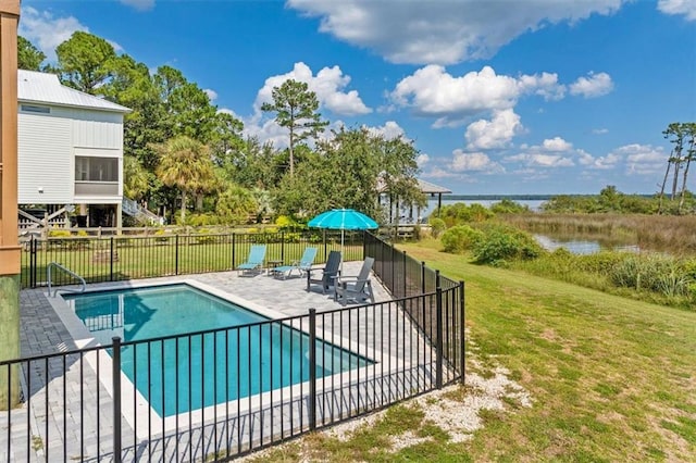 view of pool with a patio, a yard, and a water view