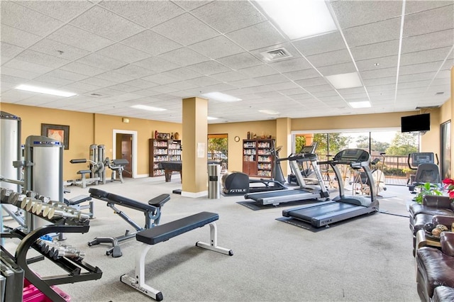 exercise room with carpet floors and a paneled ceiling