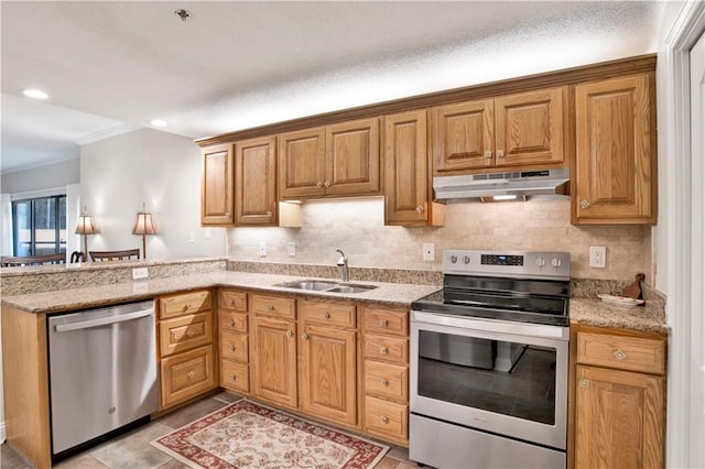 kitchen with appliances with stainless steel finishes, light stone counters, backsplash, crown molding, and sink