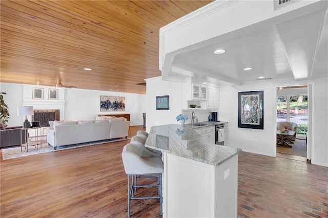 23749 Main St, Fairhope, AL 36532 - kitchen with a fireplace, a kitchen bar, white cabinets, dishwasher, and a sink