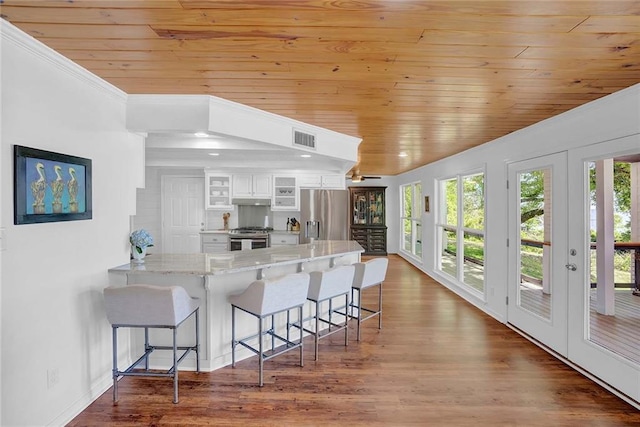 23749 Main St, Fairhope, AL 36532 - kitchen featuring stainless steel appliances, wood ceiling, plenty of natural light, a peninsula, and white cabinetry