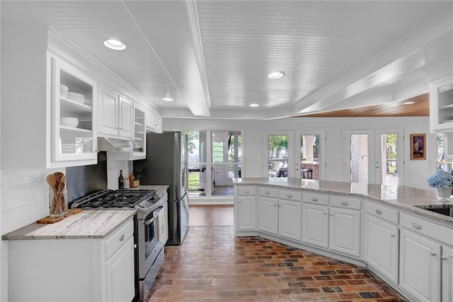 23749 Main St, Fairhope, AL 36532 - kitchen featuring stainless steel gas stove, brick flooring, white cabinets, glass insert cabinets, and recessed lighting
