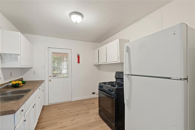 1208 Creekway Dr, Mobile, AL 36605 - kitchen with freestanding refrigerator, black gas stove, a sink, white cabinetry, and light wood-style floors
