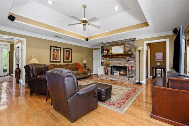 1525 Beacon Ct, Mobile, AL 36695 - living area featuring a raised ceiling, a ceiling fan, light wood finished floors, crown molding, and a brick fireplace
