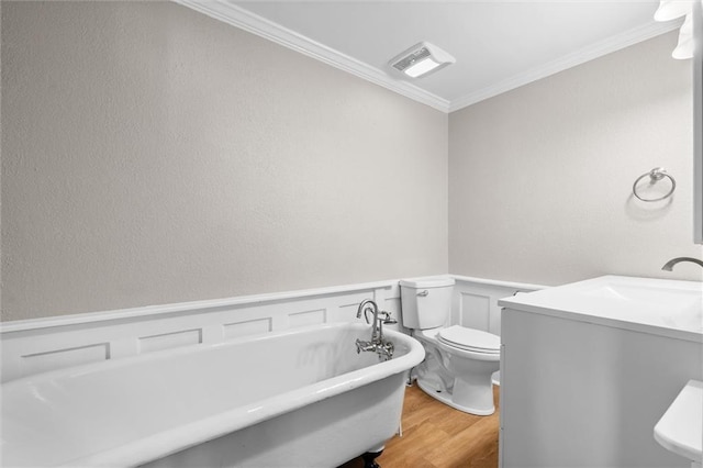 bathroom featuring vanity, crown molding, a washtub, toilet, and wood-type flooring