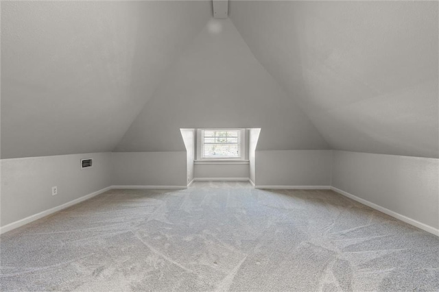 additional living space with lofted ceiling and light carpet