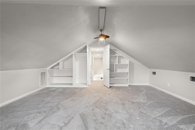 additional living space featuring ceiling fan, light colored carpet, and vaulted ceiling