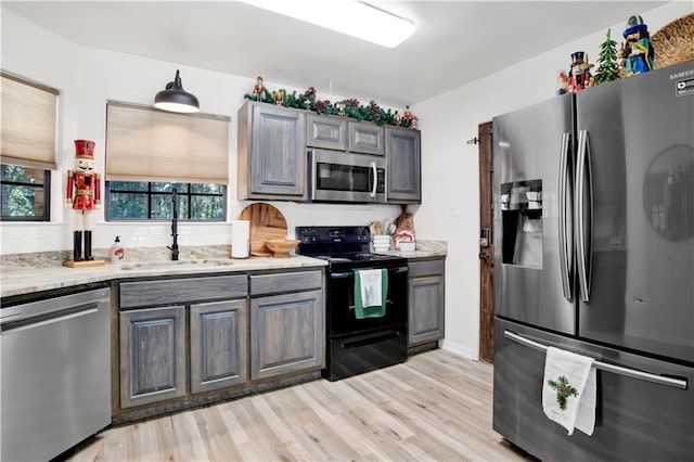 kitchen featuring gray cabinets, sink, stainless steel appliances, and light hardwood / wood-style flooring