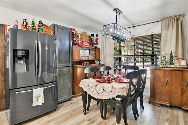 dining space featuring an inviting chandelier and light hardwood / wood-style flooring