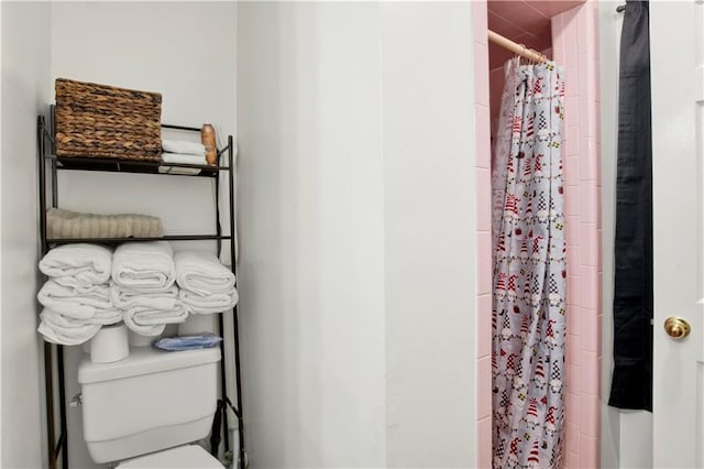 bathroom featuring a shower with shower curtain and toilet