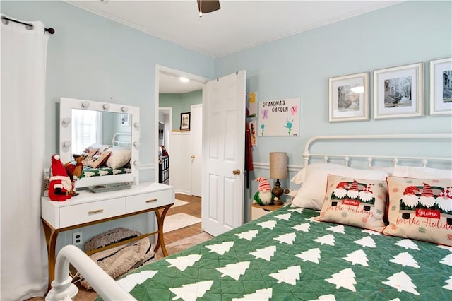 bedroom featuring hardwood / wood-style floors, ceiling fan, and crown molding