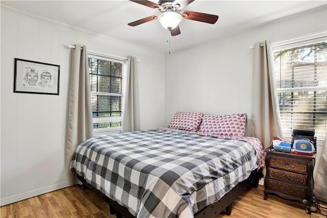 bedroom featuring wood-type flooring, ceiling fan, and ornamental molding