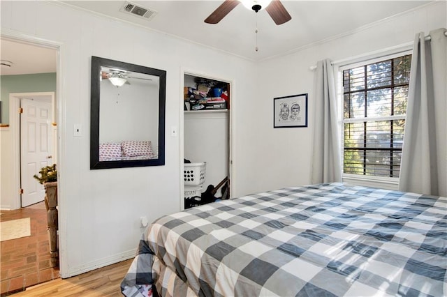 bedroom featuring light wood-type flooring, a closet, ceiling fan, and ornamental molding