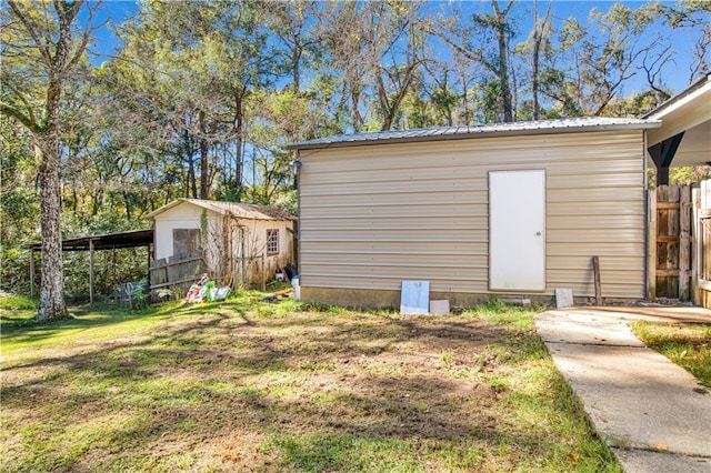 view of outbuilding featuring a lawn and a carport