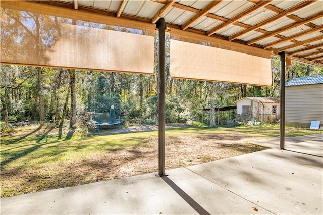 view of patio with a shed and a trampoline