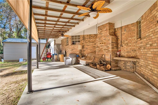 view of patio featuring ceiling fan and a storage unit