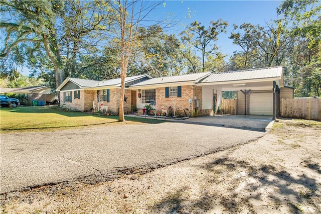 ranch-style home featuring a garage, a front yard, and a carport