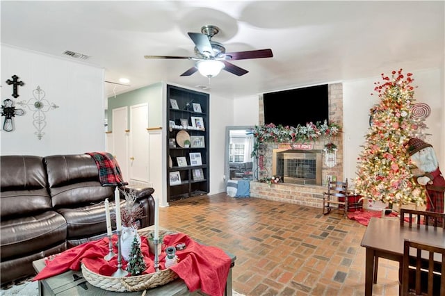 living room featuring ceiling fan and a fireplace