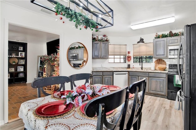 kitchen with appliances with stainless steel finishes, gray cabinets, and sink