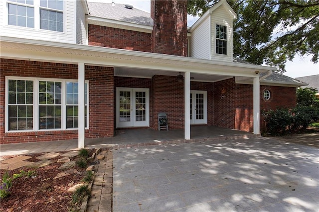 1140 Dominion Dr E, Mobile, AL 36695 - property entrance featuring french doors, brick siding, a chimney, and a patio