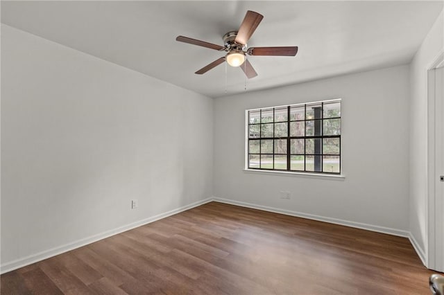 spare room featuring ceiling fan, baseboards, and wood finished floors