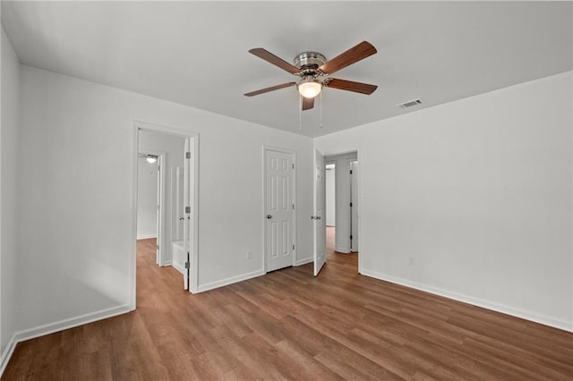 unfurnished bedroom featuring visible vents, baseboards, wood finished floors, and a ceiling fan